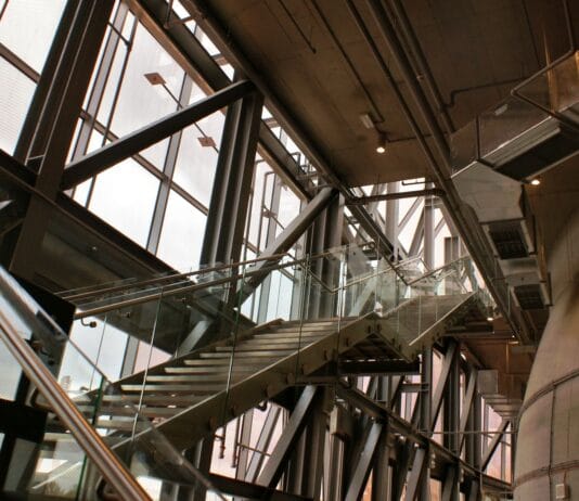 Nowoczesne industrialne schody ze szklanymi balustradami we wnętrzu
